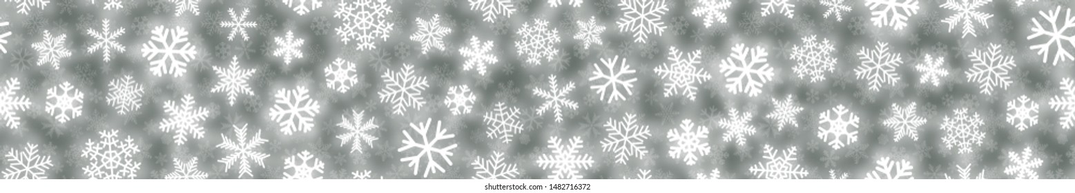 Christmas seamless pattern of white snowflakes of different shapes on gray background