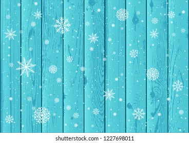 Christmas snowfall on blue wood background. Winter snowflake wooden backdrop. White snow falls