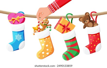 Christmas sock stocking on rope with teddy bear, gift box, gingerbread man, candy cane. Happy new year decoration. Holiday new year and xmas celebration. Vector illustration flat style