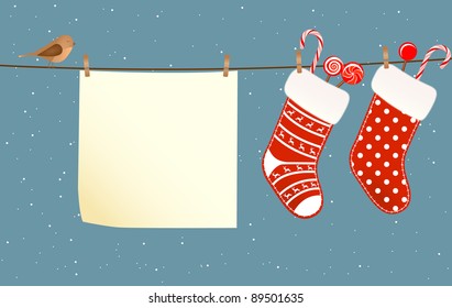 Christmas socks full of candies hanged on a clothesline next to a piece of paper