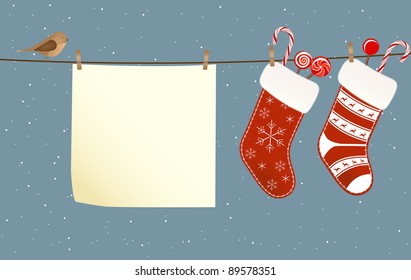 Christmas socks full of candies hanged on a clothesline next to a piece of paper