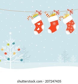 Christmas socks and Christmas tree on snowed background.
