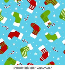 Christmas stockings, candy canes and white snowflakes on blue background seamless pattern. Vector Christmas gift socks. Flat vector Illustration.