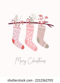 Christmas stockings hanging on a branch filled with candy canes and floral elements. Holiday greeting card.