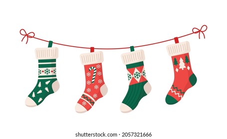 Christmas stockings with various traditional colorful holiday ornaments. Hanging children clothing elements with cute xmas patterns on rope. Red, green socks with snowflakes, snowman, christmas tree