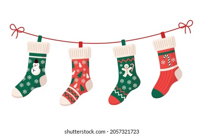 Christmas stockings with various traditional colorful holiday ornaments. Hanging children clothing elements with cute xmas patterns on rope. Red, green socks with snowflakes, snowman, christmas tree