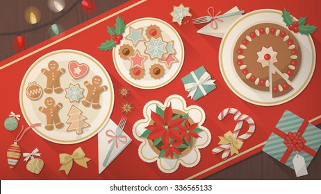 Christmas table banner, dishes with cookies, dessert and traditional gingerbread men, a poinsettia flower and gift boxes, top view