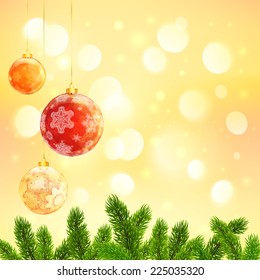 Christmas template with hanging red Christmas balls and fir tree branches on yellow bokeh background