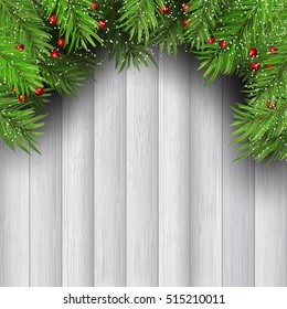Christmas tree branches with berries on wooden background
