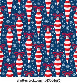 Christmas tree decorations seamless pattern of icicles with red and white stripes and a bow on dark blue background with snowflakes and snow dots. Colorful print for gift paper. Vector Illustration.