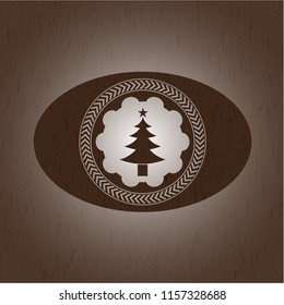 christmas tree icon inside badge with wooden background
