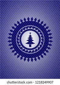 christmas tree icon inside badge with denim background
