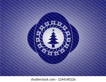 christmas tree icon inside badge with denim texture