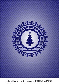 christmas tree icon inside badge with denim background