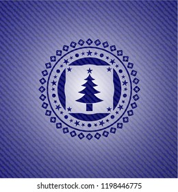 christmas tree icon inside emblem with denim texture