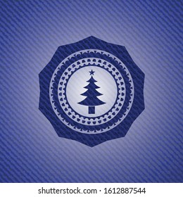 christmas tree icon inside emblem with denim high quality background