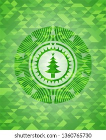 christmas tree icon inside green emblem with triangle mosaic background