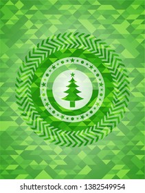 christmas tree icon inside green emblem with mosaic background