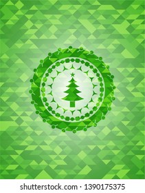 christmas tree icon inside green mosaic emblem