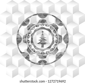 christmas tree icon inside grey badge with geometric cube white background
