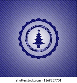 christmas tree icon inside jean or denim emblem or badge background
