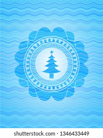 christmas tree icon inside sky blue water style badge.