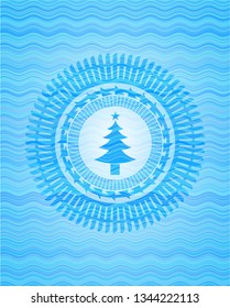 christmas tree icon inside water wave representation style badge.