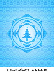 christmas tree icon inside water wave style emblem. 