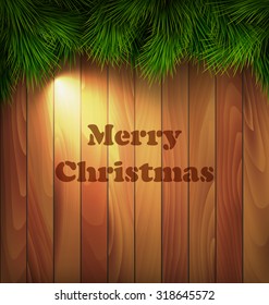 Christmas Tree Pine Branches with Light on Wooden Background