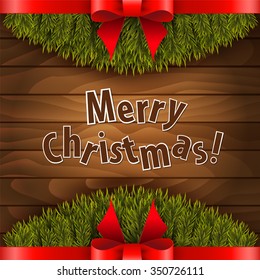 Christmas tree with red bow on the wood background.