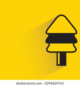 Christmas tree with shadow on yellow background