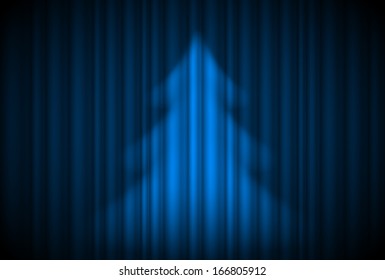 Christmas tree in spotlight on blue curtain. Theatre style.