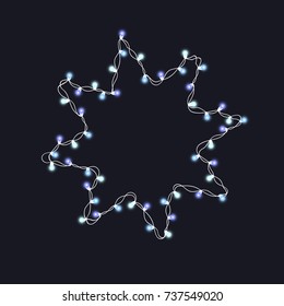 Christmas tree string blue garland in star shape and text space isolated on dark background. Realistic Christmas, New Year party decorations with transparency. Light bulb decor. Lights border