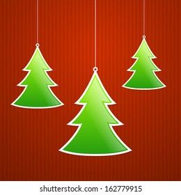 Christmas trees are hanging on striped background