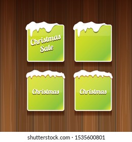Christmas vector green glossy buttons set isolated on wooden background. web green christmas sale buttons with snow, ice border