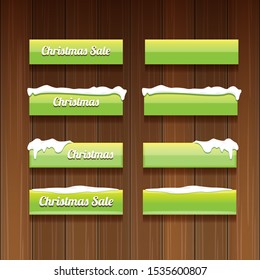 Christmas vector green glossy buttons set isolated on wooden background. web green christmas sale buttons with snow, ice border
