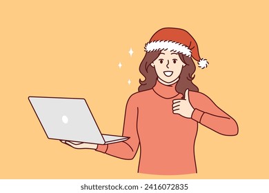 Christmas woman with laptop shows thumbs up recommending online shopping during new year holidays. Girl in santa hat holds computer inviting customers to buy christmas travel packages via internet.