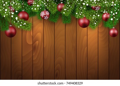 Christmas wooden background with fir branches and balls.