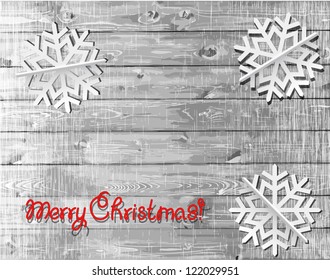 Christmas wooden background  with white paper snowflakes.