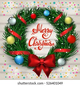 Christmas wreath with balls and confetti on wooden background. Merry Christmas - hand lettering. 