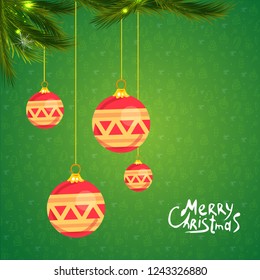 Christmas-tree branch with hanging christmas ornaments and garland and the greetings text - Merry Xmas - and happy new year.
