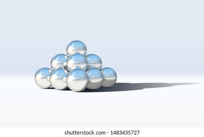 Chrome metal balls in pyramid stack on abstract calm and relaxing white background