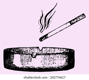 cigarette in an ashtray isolated over a pink background with a clipping path