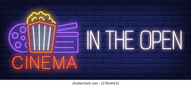 Cinema in the open neon sign. Popcorn box, film reel, clapper on brick wall background. Vector illustration in neon style for movie outdoors