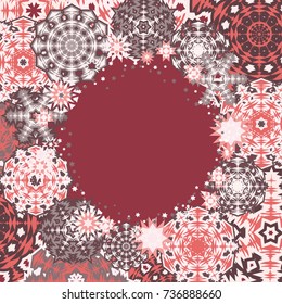 Circle Christmas frame or border with random scatter falling snowflakes on a burgundy background.