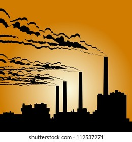 Circuit of industrial buildings and smoking chimneys against the setting sun.