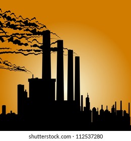 Circuit of industrial buildings and smoking chimneys against the setting sun.