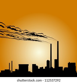 Circuit of industrial buildings and smoking chimneys against the setting sun.