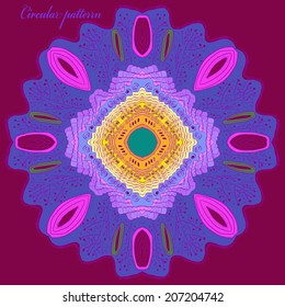 Circular multicolored ornament  and purple text on a dark rosy background. Handmade.