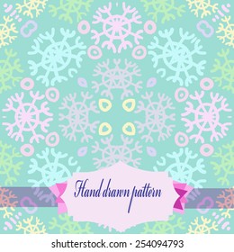 Circular   pattern of colored  motifs, snowflakes, label  on a pale azure    background. Hand drawn. 